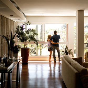 a man and woman standing in a room with a window