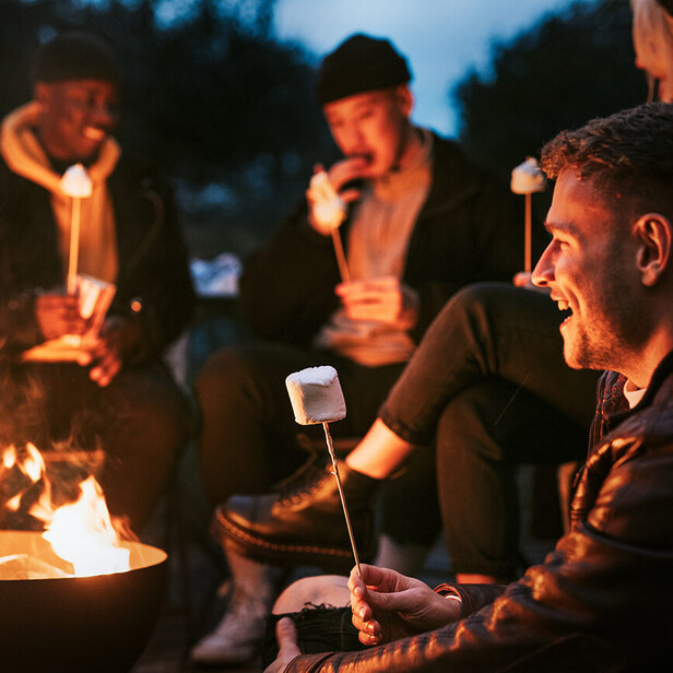 smiling people roasting marshmallows