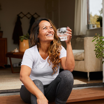a woman sitting on a step drinking water